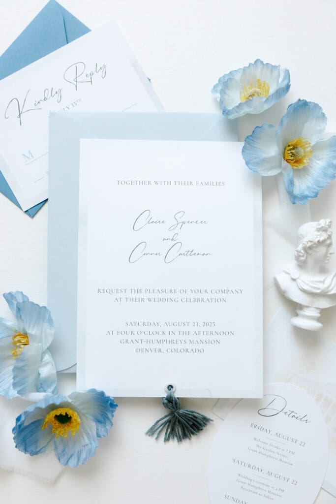 Blue and white wedding invitation with tassel detail, coordinating envelope and oval details card